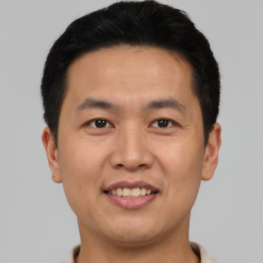 Joyful asian young-adult male with short  black hair and brown eyes