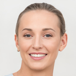 Joyful white young-adult female with short  brown hair and grey eyes