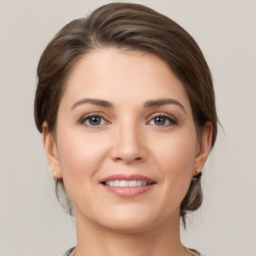 Joyful white young-adult female with medium  brown hair and grey eyes