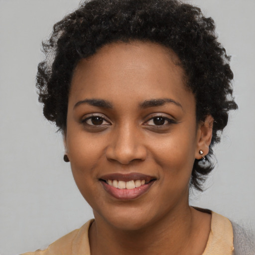 Joyful black young-adult female with short  black hair and brown eyes