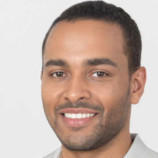 Joyful black young-adult male with short  black hair and brown eyes