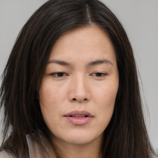 Joyful asian young-adult female with long  brown hair and brown eyes