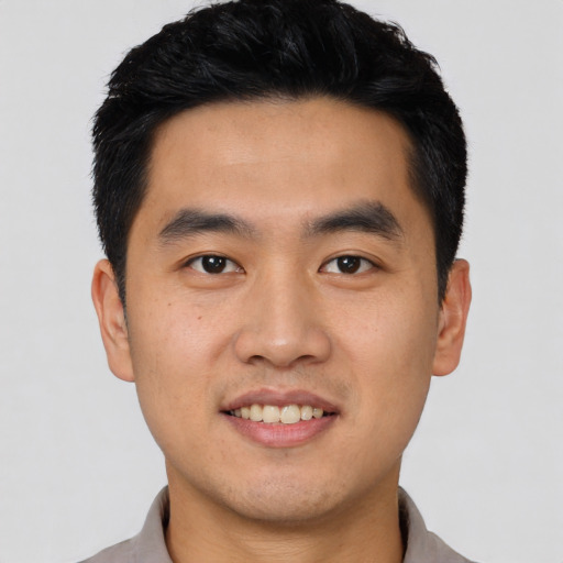 Joyful asian young-adult male with short  black hair and brown eyes
