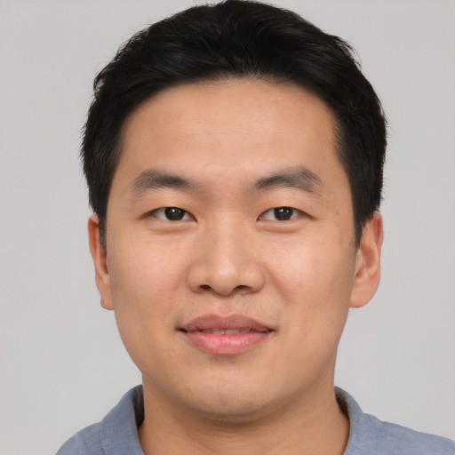 Joyful asian young-adult male with short  black hair and brown eyes