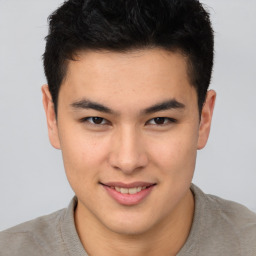 Joyful asian young-adult male with short  brown hair and brown eyes