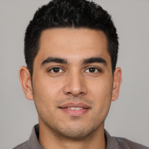 Joyful white young-adult male with short  black hair and brown eyes