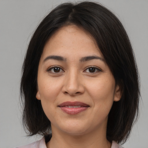 Joyful latino young-adult female with medium  brown hair and brown eyes