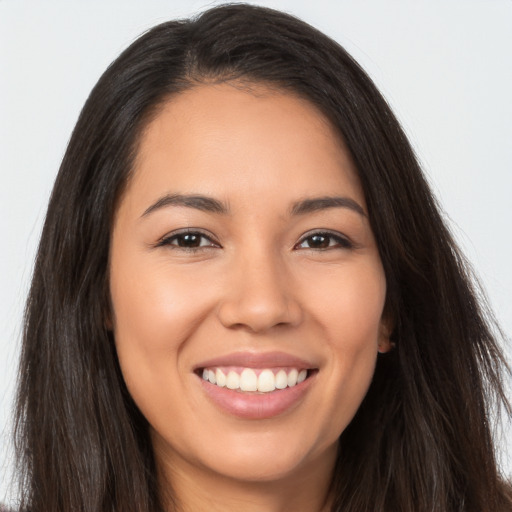 Joyful latino young-adult female with long  brown hair and brown eyes