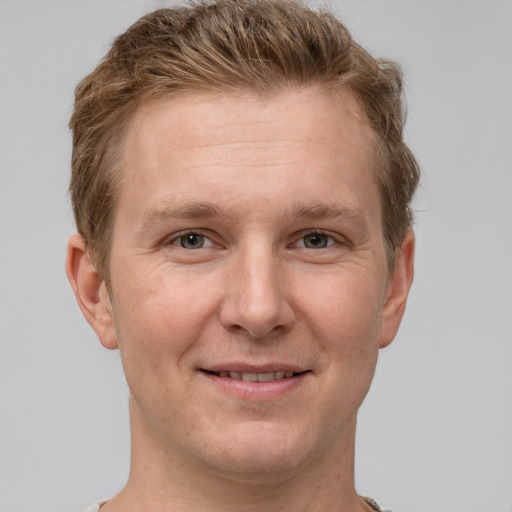 Joyful white adult male with short  brown hair and grey eyes