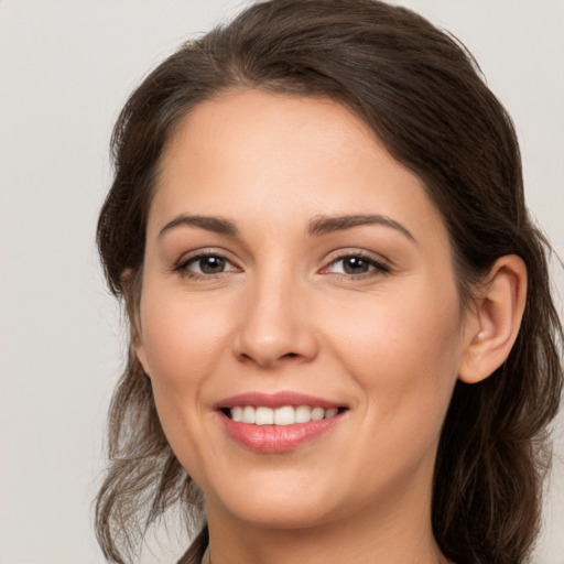 Joyful white young-adult female with long  brown hair and brown eyes