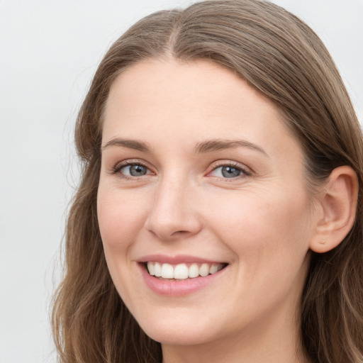 Joyful white young-adult female with long  brown hair and blue eyes