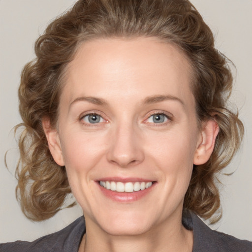 Joyful white young-adult female with medium  brown hair and blue eyes