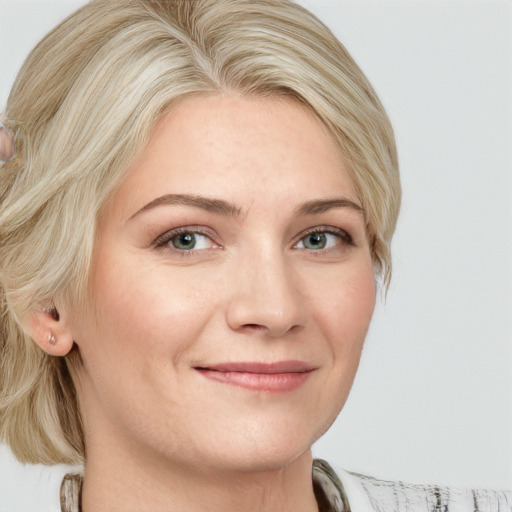 Joyful white adult female with medium  blond hair and blue eyes