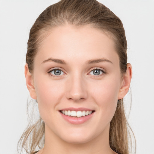 Joyful white young-adult female with long  brown hair and blue eyes