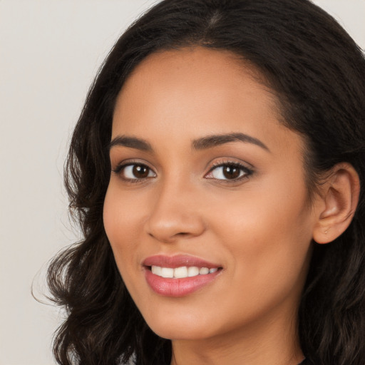 Joyful latino young-adult female with long  brown hair and brown eyes