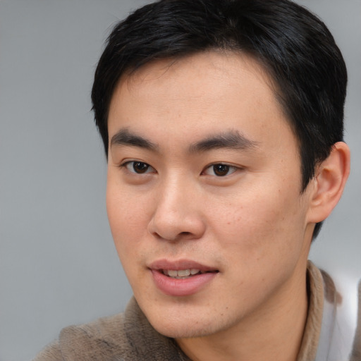 Joyful asian young-adult male with short  brown hair and brown eyes