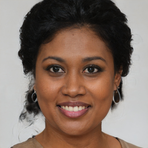 Joyful black young-adult female with medium  brown hair and brown eyes