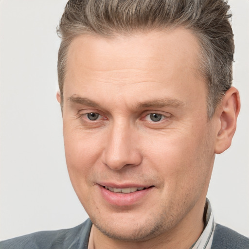 Joyful white adult male with short  brown hair and brown eyes