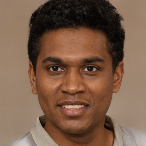 Joyful black young-adult male with short  black hair and brown eyes