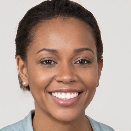 Joyful black young-adult female with short  brown hair and brown eyes