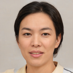 Joyful asian young-adult female with medium  brown hair and brown eyes