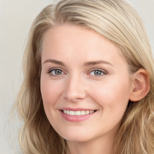 Joyful white young-adult female with long  brown hair and blue eyes