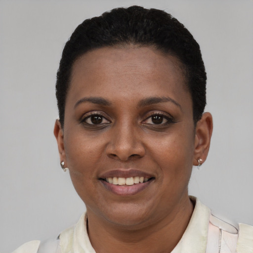 Joyful black young-adult female with short  brown hair and brown eyes