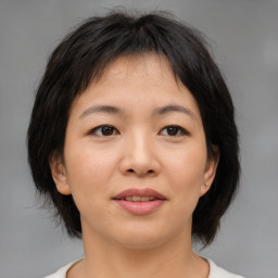 Joyful asian young-adult female with medium  brown hair and brown eyes