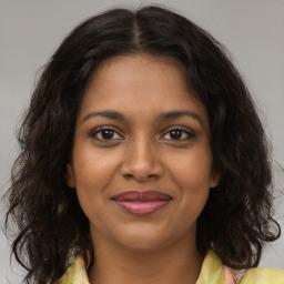 Joyful black young-adult female with medium  brown hair and brown eyes