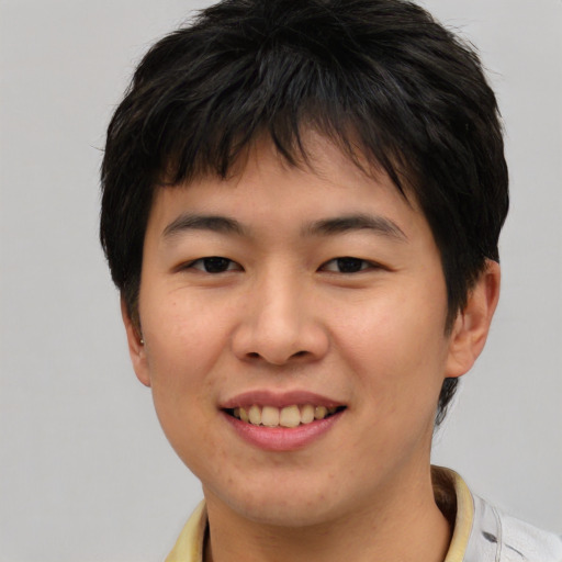 Joyful asian young-adult female with short  brown hair and brown eyes