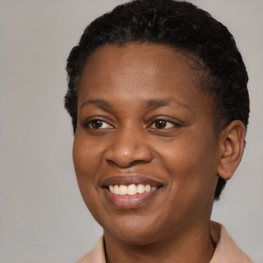 Joyful black young-adult female with short  black hair and brown eyes