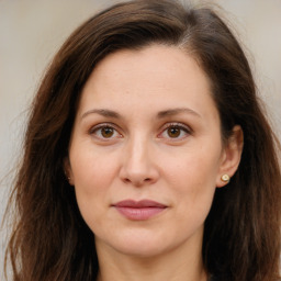 Joyful white adult female with long  brown hair and brown eyes