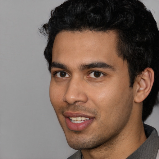 Joyful latino young-adult male with short  black hair and brown eyes