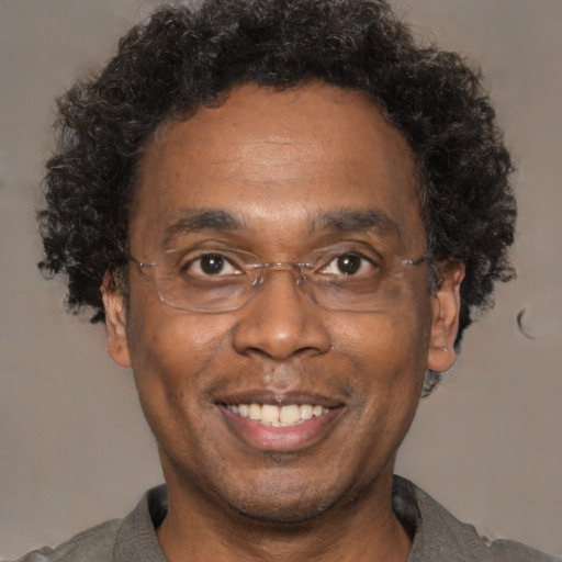 Joyful black adult male with short  brown hair and brown eyes