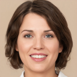 Joyful white young-adult female with medium  brown hair and green eyes