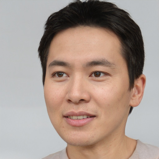 Joyful asian young-adult male with short  brown hair and brown eyes