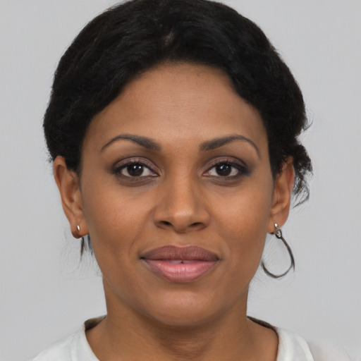 Joyful black young-adult female with short  black hair and brown eyes