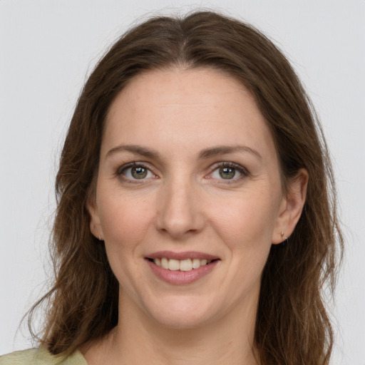 Joyful white adult female with long  brown hair and green eyes