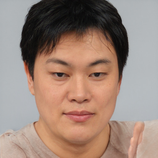 Joyful asian young-adult male with short  brown hair and brown eyes