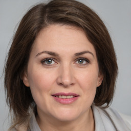 Joyful white adult female with medium  brown hair and grey eyes