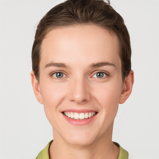 Joyful white young-adult female with short  brown hair and grey eyes