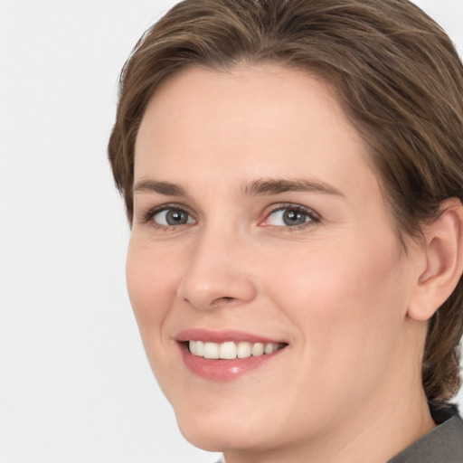 Joyful white young-adult female with medium  brown hair and grey eyes