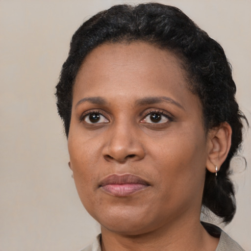 Joyful black adult female with short  black hair and brown eyes