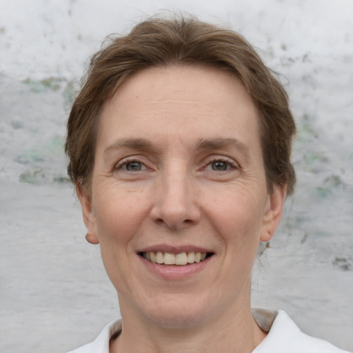 Joyful white adult female with short  brown hair and grey eyes