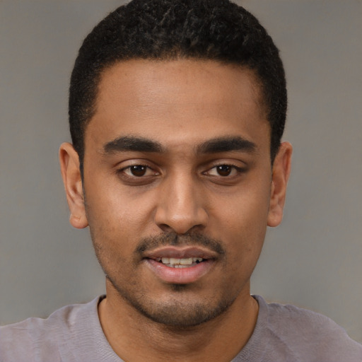 Joyful black young-adult male with short  black hair and brown eyes