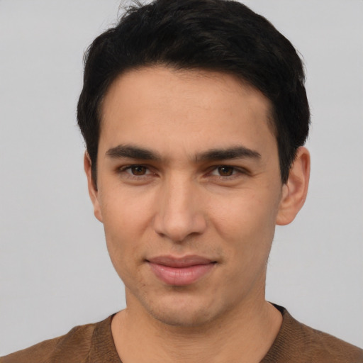 Joyful white young-adult male with short  black hair and brown eyes