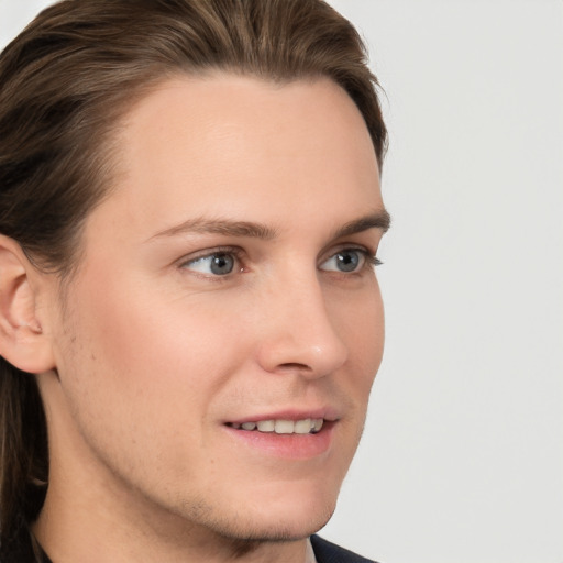 Joyful white young-adult male with medium  brown hair and grey eyes