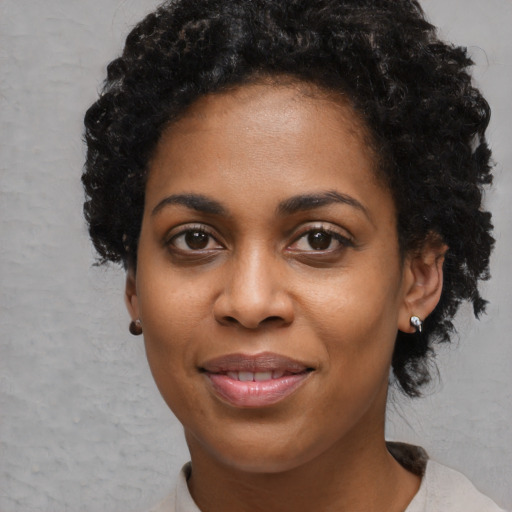 Joyful black young-adult female with short  black hair and brown eyes