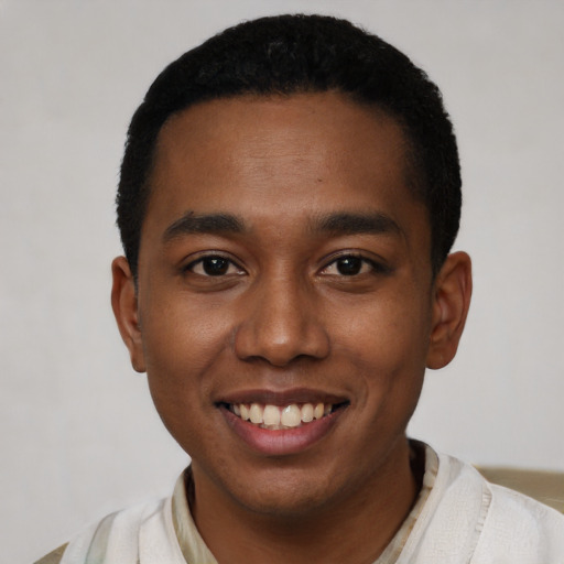 Joyful black young-adult male with short  black hair and brown eyes