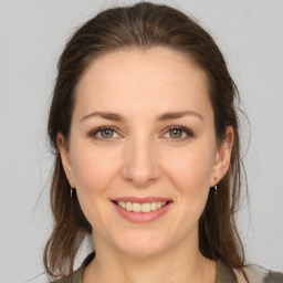 Joyful white young-adult female with medium  brown hair and grey eyes